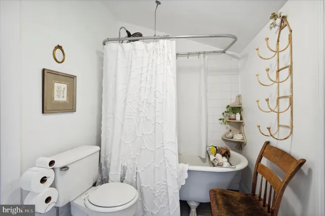 a white toilet sitting next to a bathroom sink and a shower