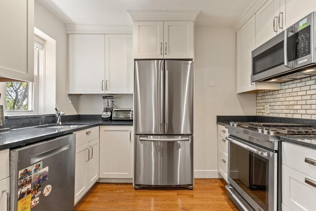 395 Broadway, Unit R5E Cambridge, MA 02139 - Photo 11 of 27 a kitchen with granite countertop a sink stove and refrigerator
