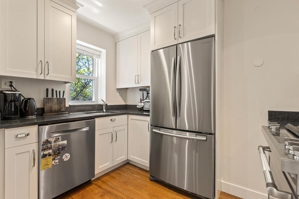 395 Broadway, Unit R5E Cambridge, MA 02139 - Photo 12 of 27 a kitchen with appliances a sink and a window