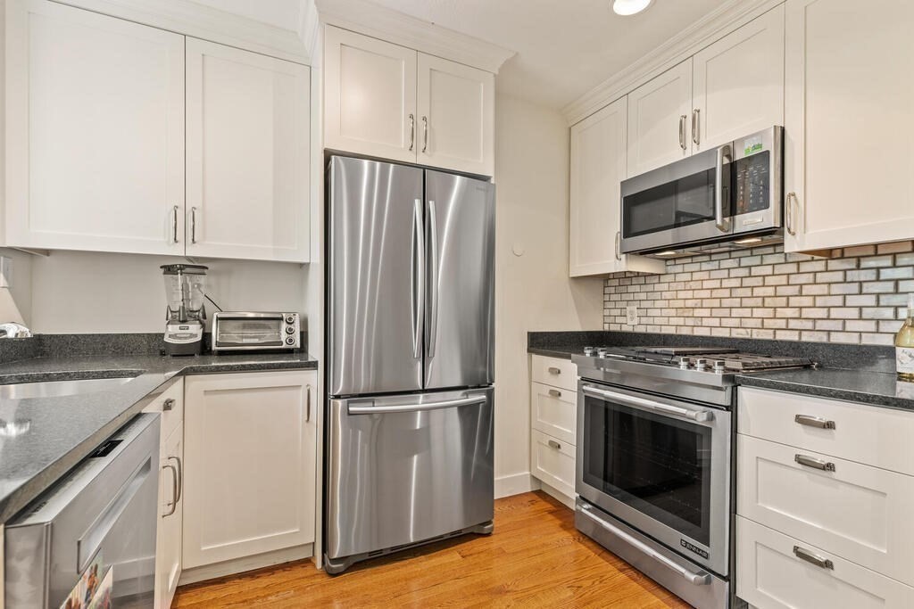 395 Broadway, Unit R5E Cambridge, MA 02139 - Photo 13 of 27 a kitchen with cabinets stainless steel appliances and wooden floor