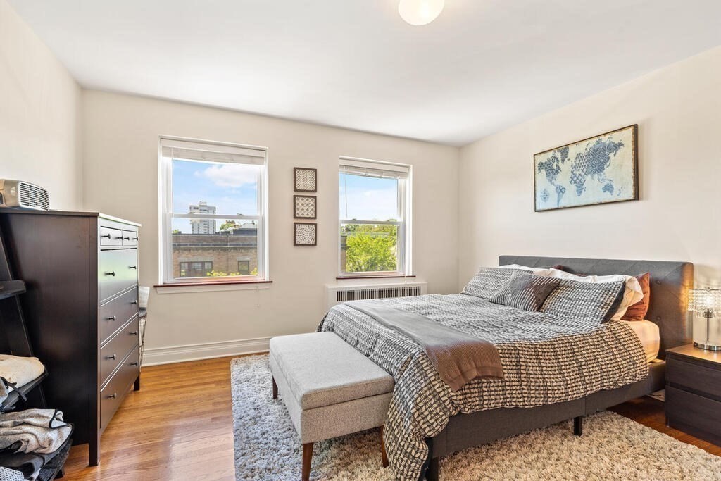 395 Broadway, Unit R5E Cambridge, MA 02139 - Photo 17 of 27 a bedroom with a bed and wooden floor