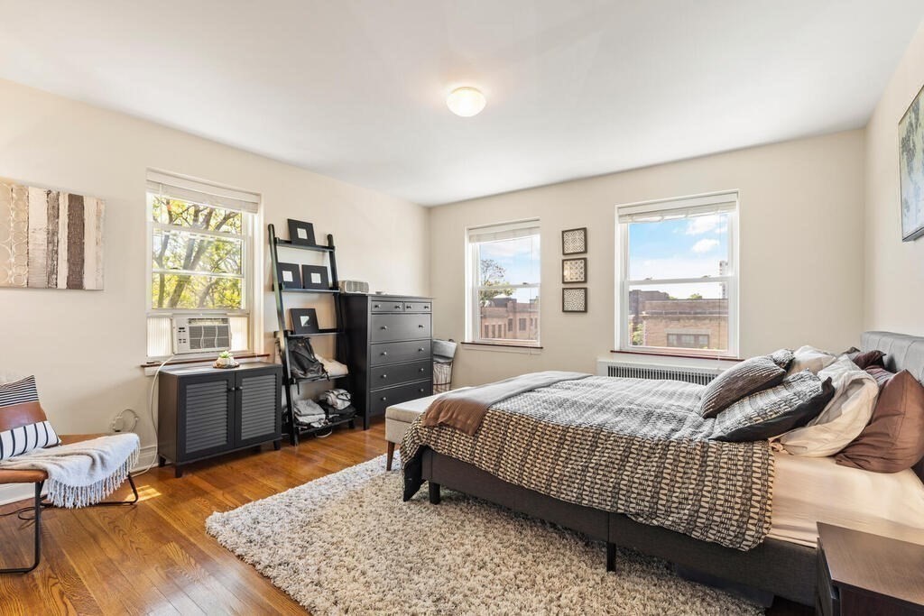 395 Broadway, Unit R5E Cambridge, MA 02139 - Photo 18 of 27 a bedroom with a bed furniture and windows
