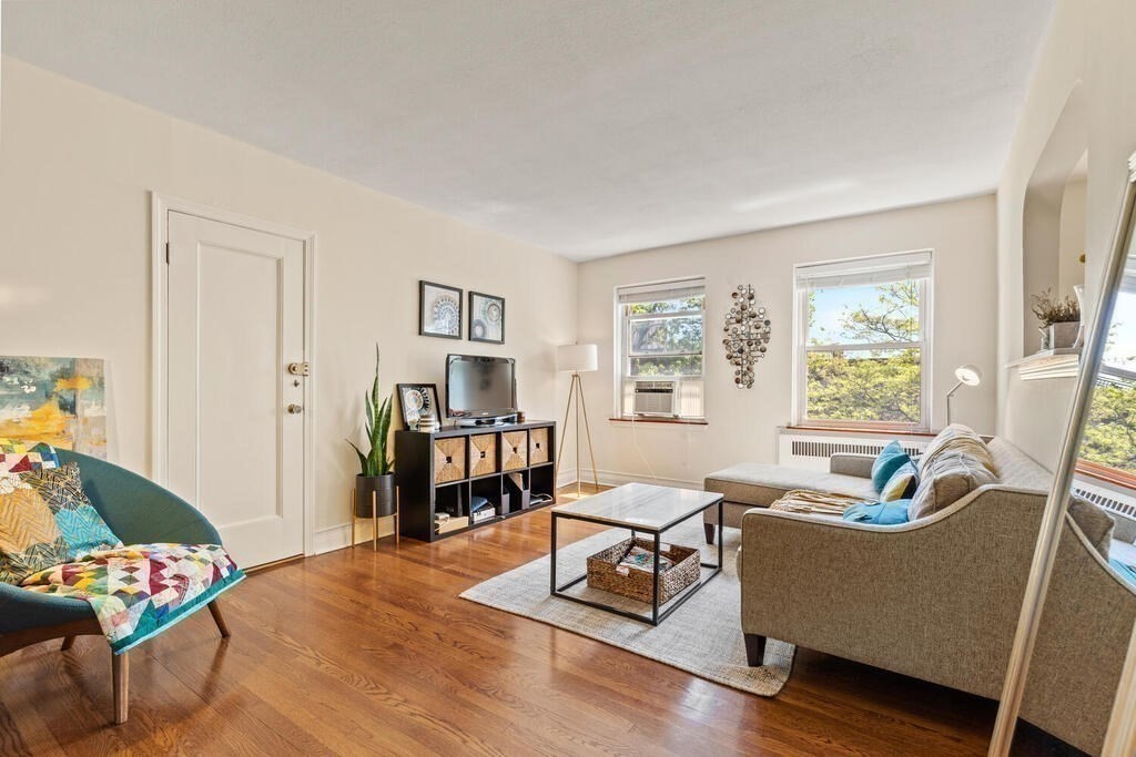 395 Broadway, Unit R5E Cambridge, MA 02139 - Photo 5 of 27 a living room with furniture and a large window