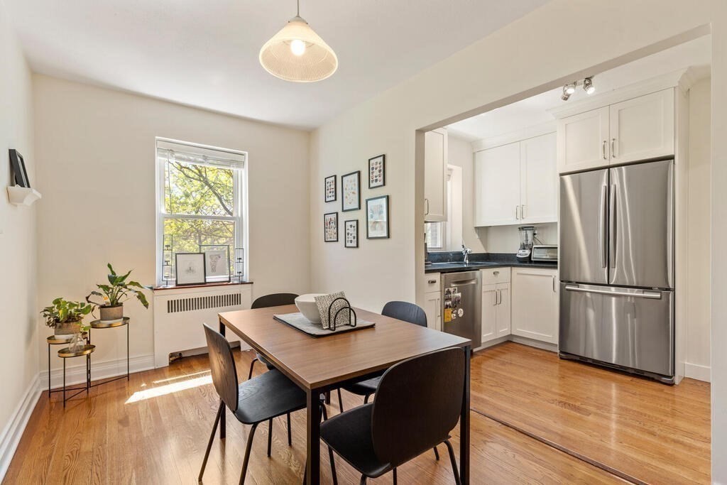 395 Broadway, Unit R5E Cambridge, MA 02139 - Photo 9 of 27 a kitchen with stainless steel appliances a dining table and chairs