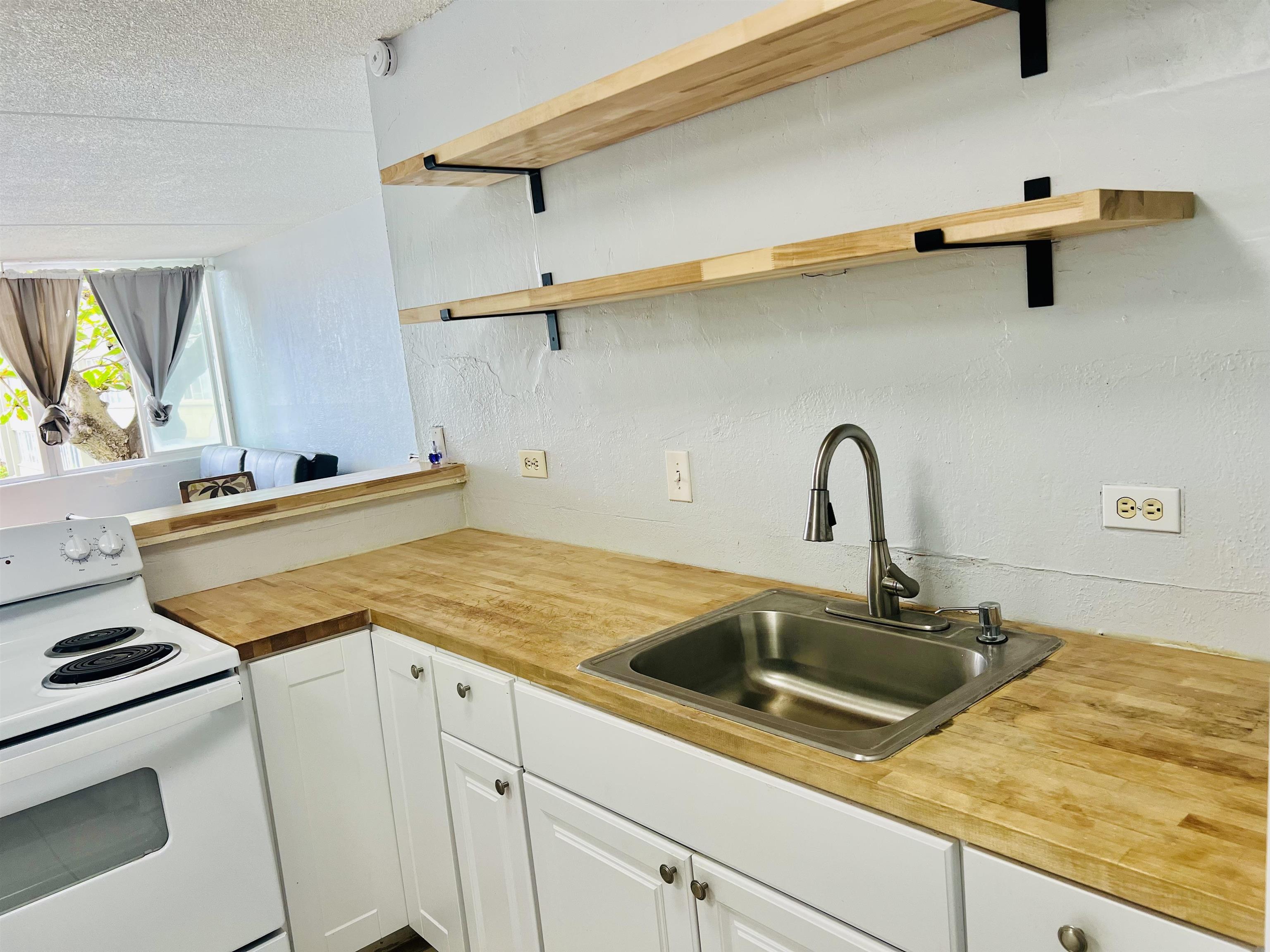 111 Kahului Beach Road, Unit D225 Kahului, HI 96732 - Photo 22 of 31 a kitchen with a sink and a stove top oven