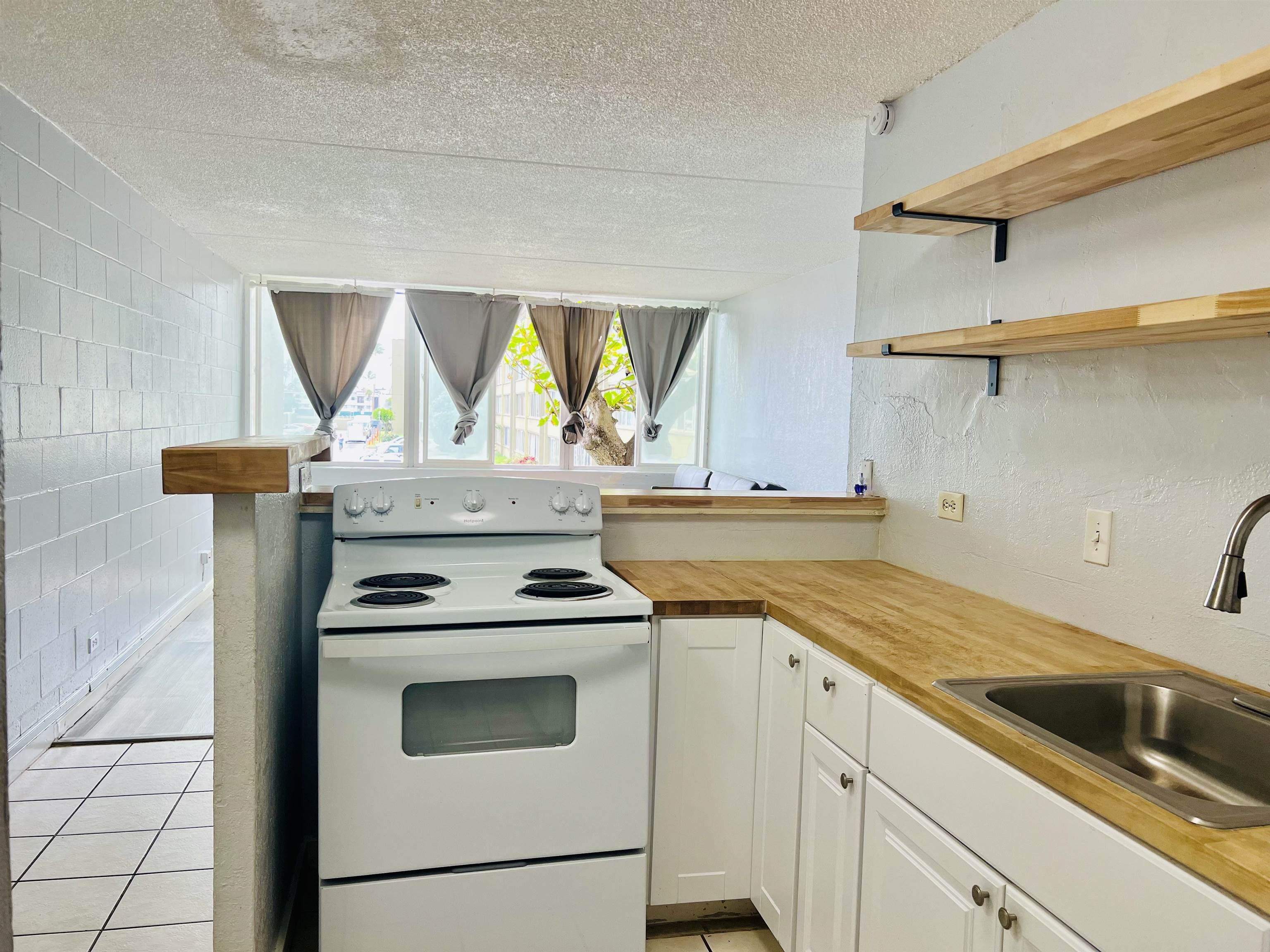 111 Kahului Beach Road, Unit D225 Kahului, HI 96732 - Photo 23 of 31 a kitchen with a stove and a sink