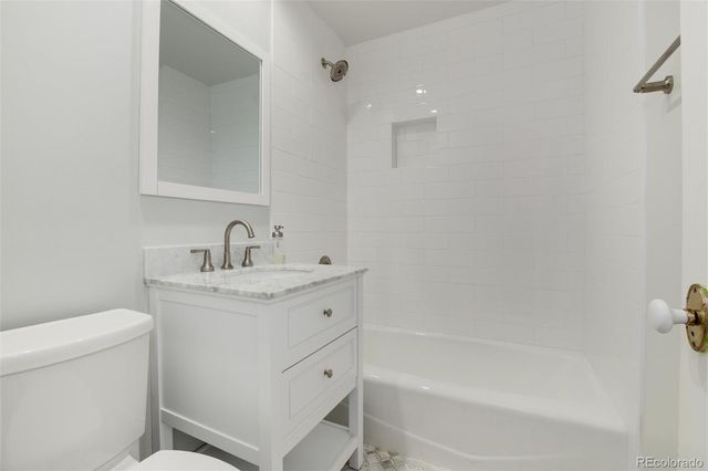 a bathroom with a tub sink double vanity and mirror