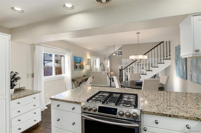 a kitchen with granite countertop a sink stove and cabinets