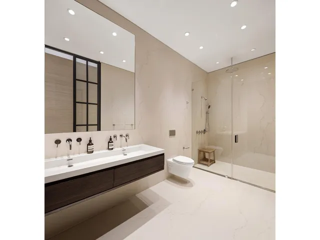 a bathroom with a double vanity sink mirror and toilet