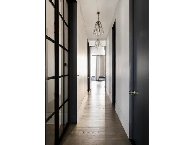 a view of a hallway with wooden floor and windows