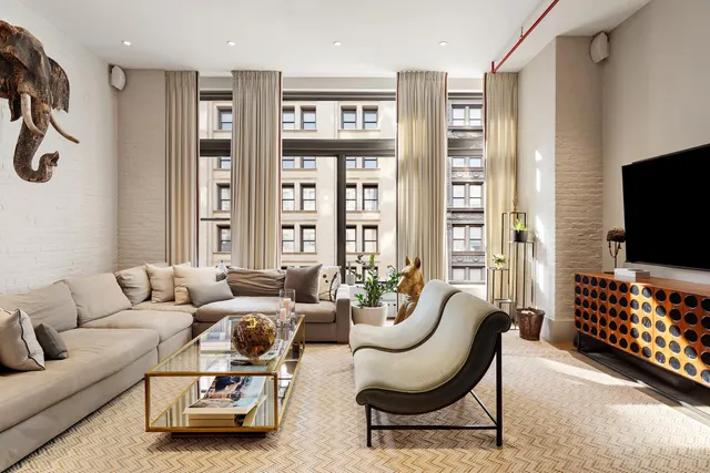 a living room with furniture a flat screen tv and a window