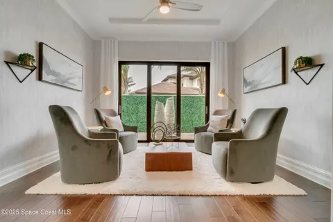 a spacious bedroom with a large bed a chandelier and windows