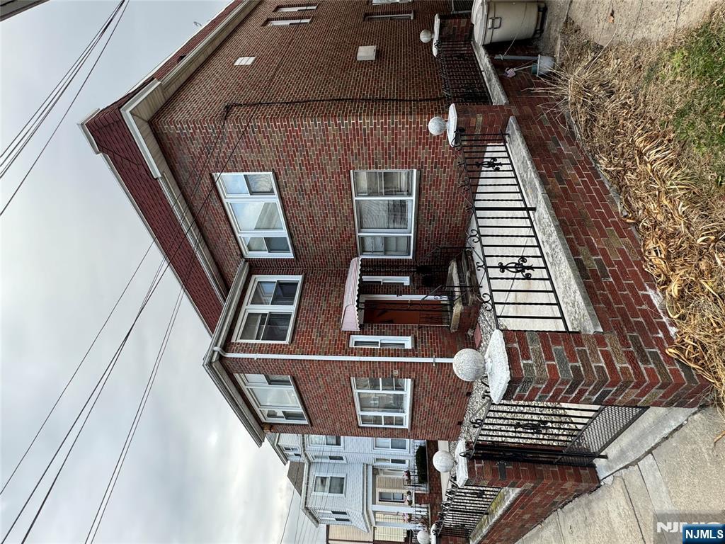 a view of a brick house with wooden fence
