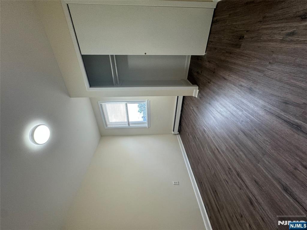 310 Elm Street, Unit 2R Kearny, NJ 07032 - Photo 11 of 14 an empty room with wooden floor and windows