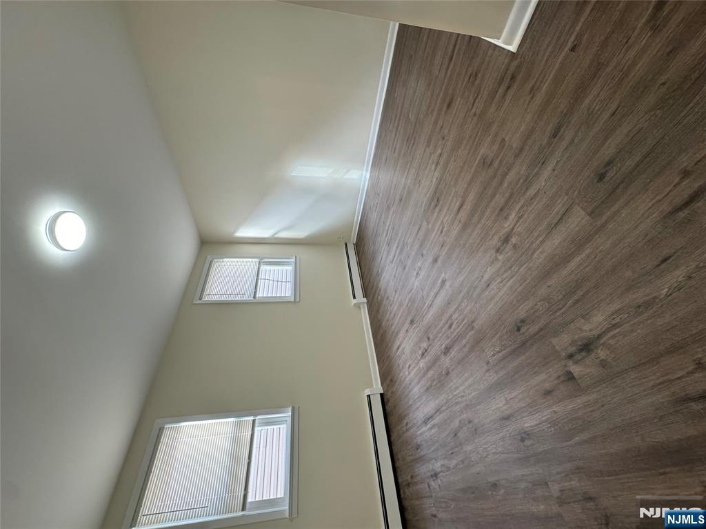 310 Elm Street, Unit 2R Kearny, NJ 07032 - Photo 3 of 14 an empty room with wooden floor and windows