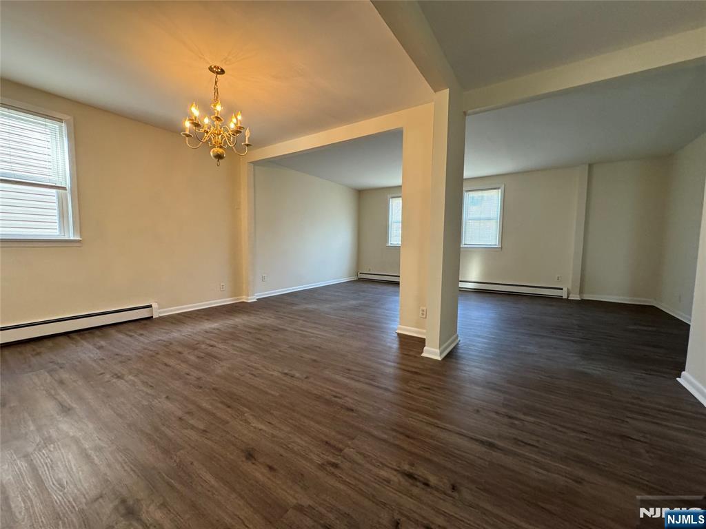 310 Elm Street, Unit 2R Kearny, NJ 07032 - Photo 4 of 14 an empty room with wooden floor chandelier and windows