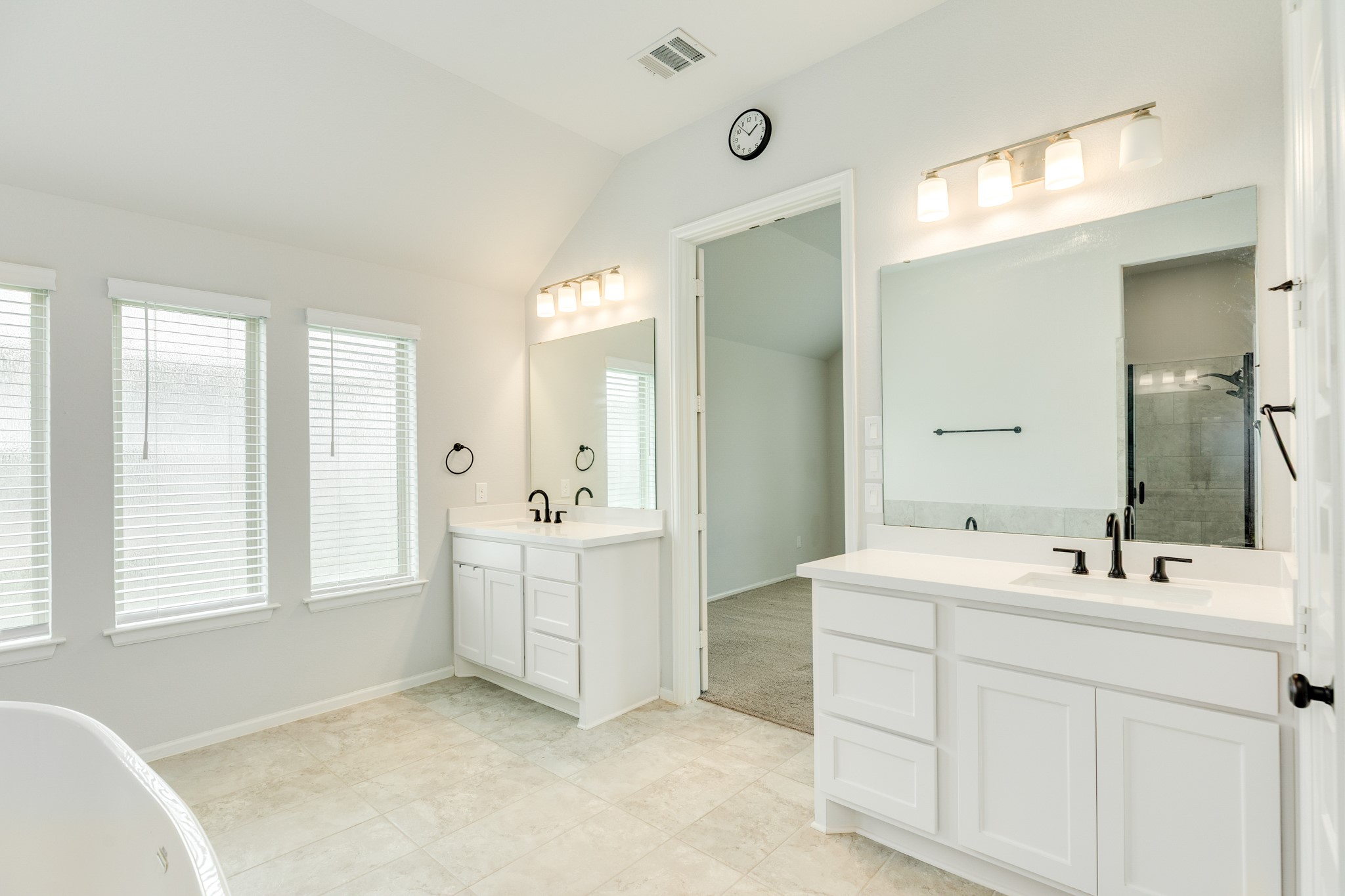 10115 Stride Court Rosharon, TX 77583 - Photo 16 of 40 Primary bath features a spacious layout with double vanities, upgraded lighting, elegant tile flooring, and large windows that invite abundant natural light.