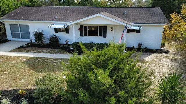 a front view of house with yard and trees in the background