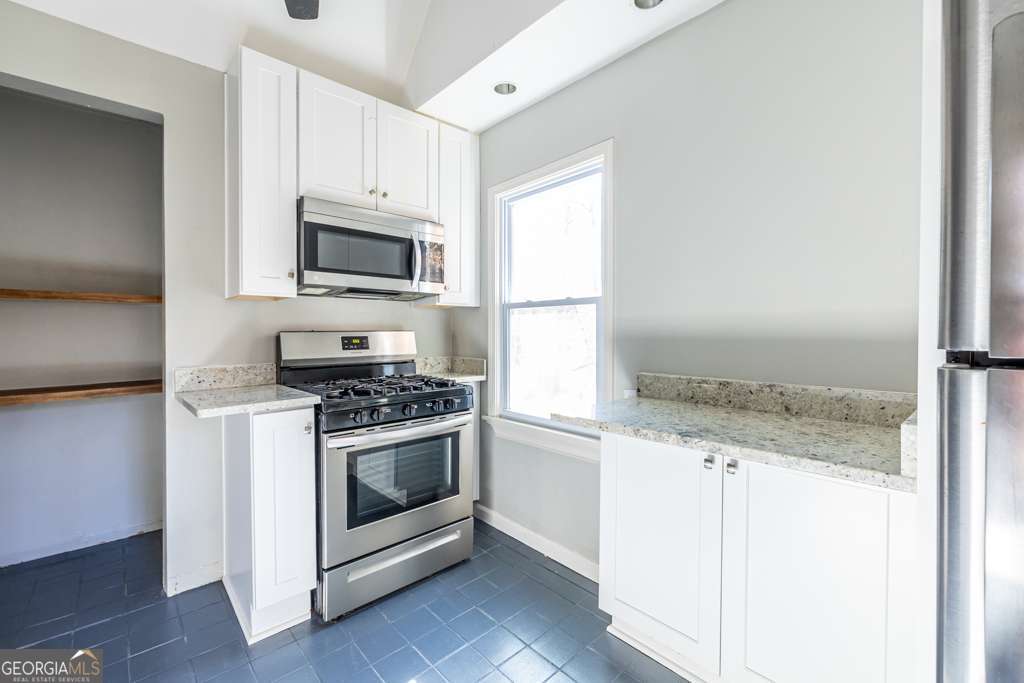 1570 Spring Lane Northwest, Unit B Atlanta, GA 30314 - Photo 13 of 26 a kitchen with granite countertop a stove and a microwave