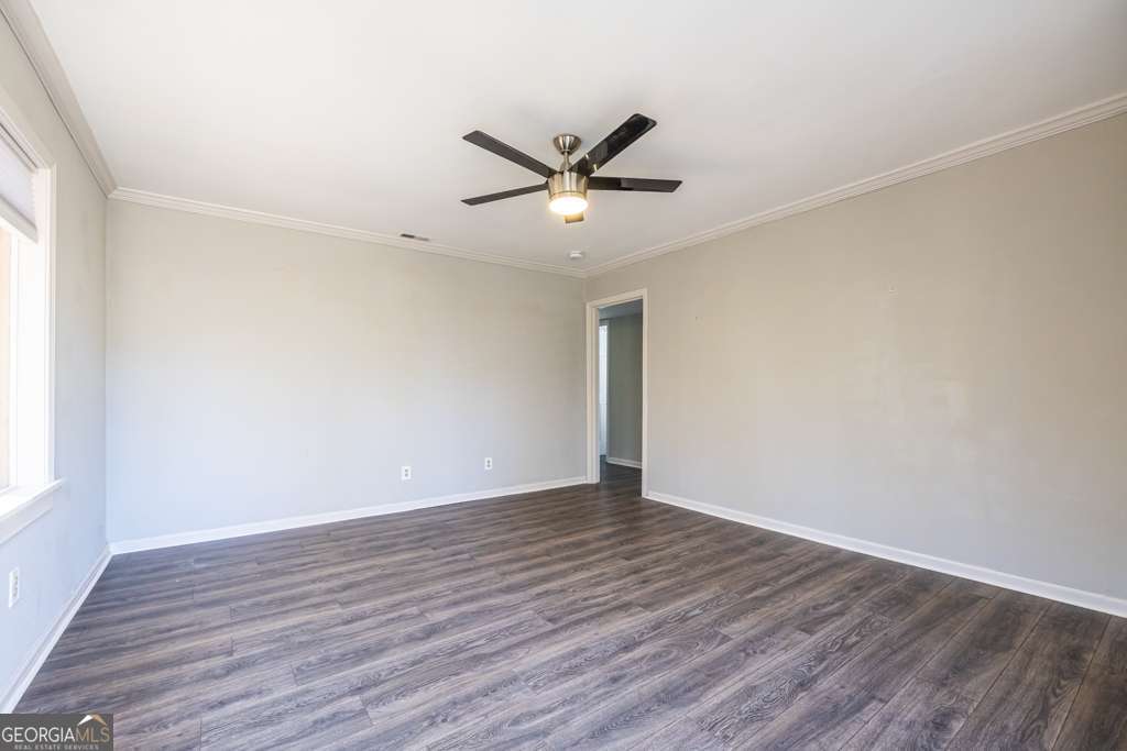 1570 Spring Lane Northwest, Unit B Atlanta, GA 30314 - Photo 6 of 26 an empty room with wooden floor a ceiling fan and windows