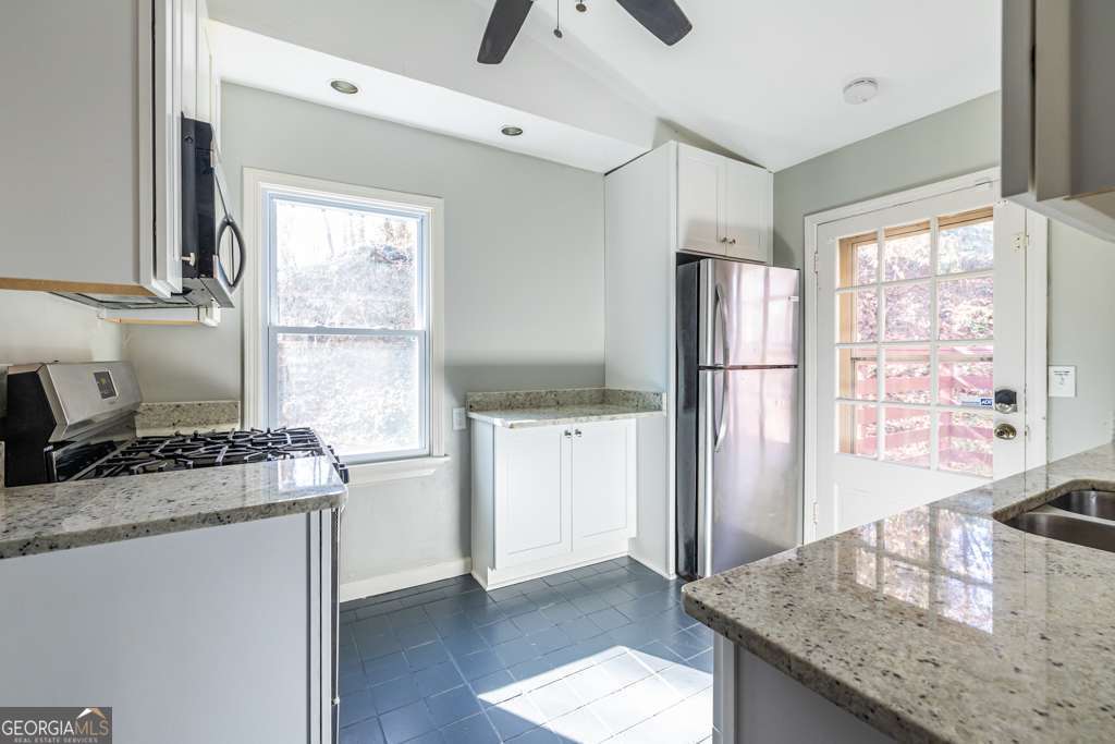 1570 Spring Lane Northwest, Unit B Atlanta, GA 30314 - Photo 10 of 26 a kitchen with granite countertop a stove and a refrigerator