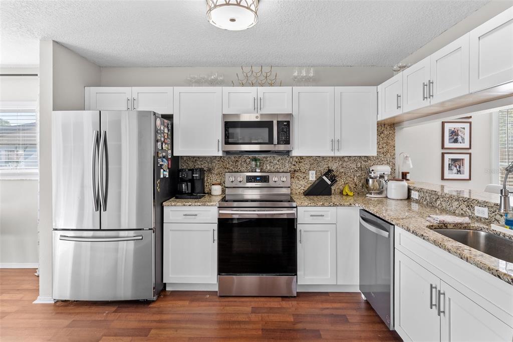 3323 West Pine Street Tampa, FL 33607 - Photo 13 of 32 a kitchen with stainless steel appliances granite countertop a refrigerator stove a sink and a microwave
