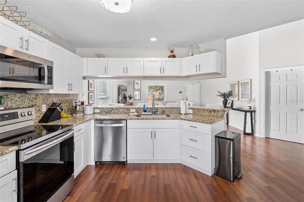 3323 West Pine Street Tampa, FL 33607 - Photo 16 of 32 a kitchen with granite countertop white cabinets and white appliances