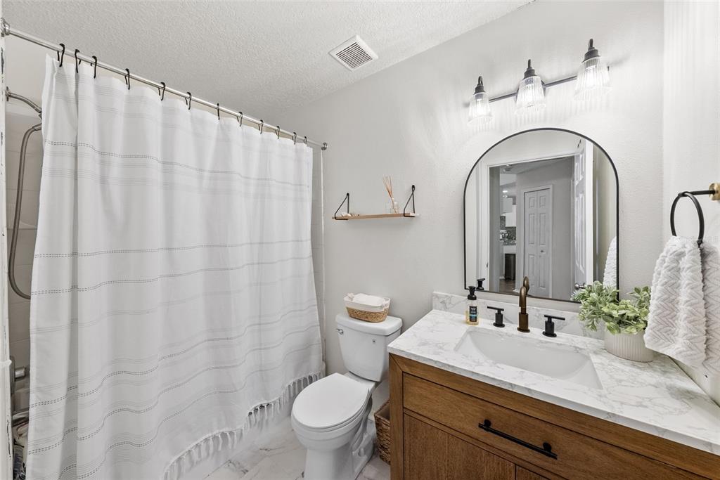 3323 West Pine Street Tampa, FL 33607 - Photo 21 of 32 a bathroom with a granite countertop sink a toilet and a mirror
