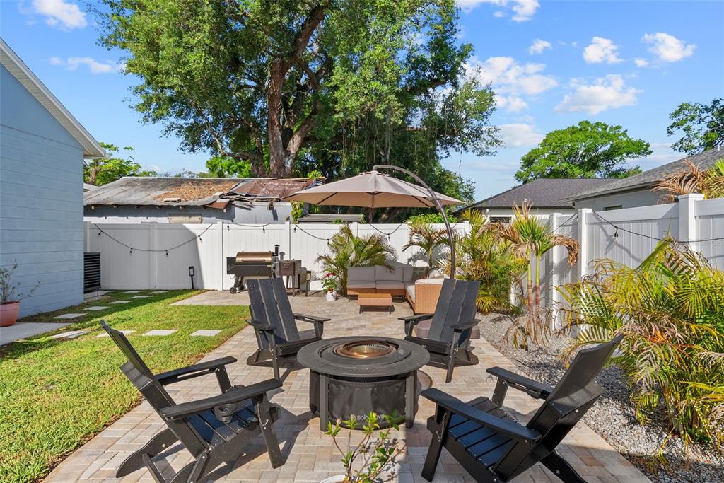 3323 West Pine Street Tampa, FL 33607 - Photo 26 of 32 a view of a patio with table and chairs potted plants and a palm tree