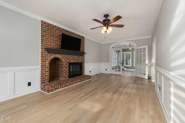 a view of an empty room with a window and wooden floor