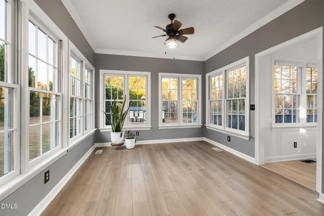 a dining room with furniture potted plants and wooden floor