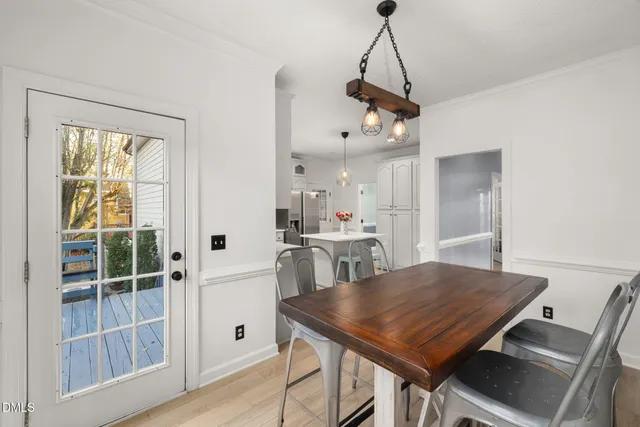 a kitchen with stainless steel appliances kitchen island granite countertop a refrigerator a sink dishwasher and white cabinets with wooden floor