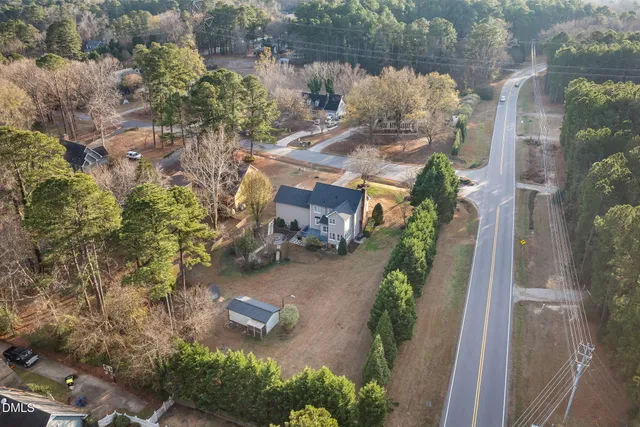 a view of a livingroom with a fireplace a ceiling fan and windows