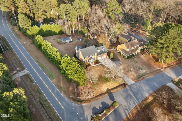 a view of a livingroom with a fireplace a ceiling fan and windows