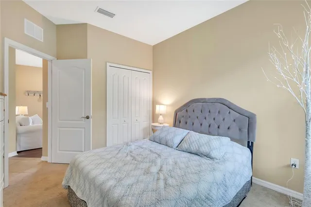 a spacious bedroom with a bed and mirror