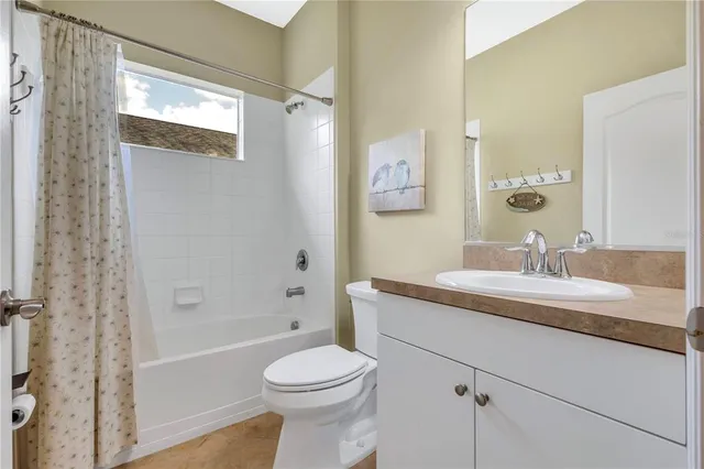 a bathroom with a granite countertop sink a toilet and shower