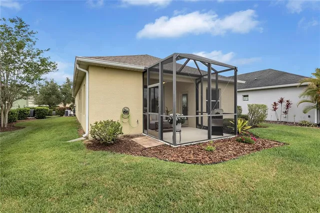 a view of a chair and table in backyard of the house