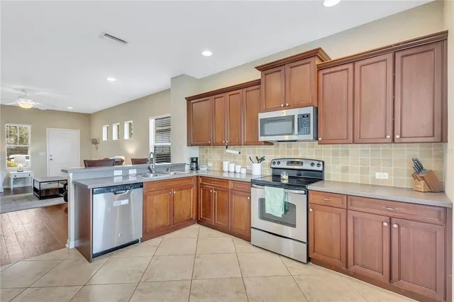 a kitchen with stainless steel appliances granite countertop wooden cabinets a sink and dishwasher