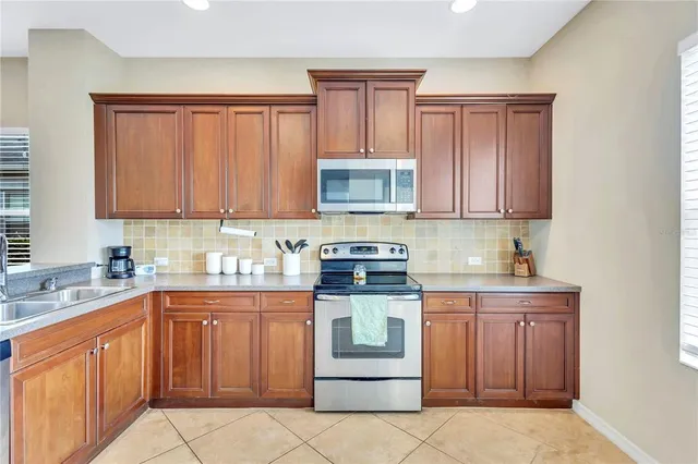 a kitchen with stainless steel appliances granite countertop a stove sink and cabinets