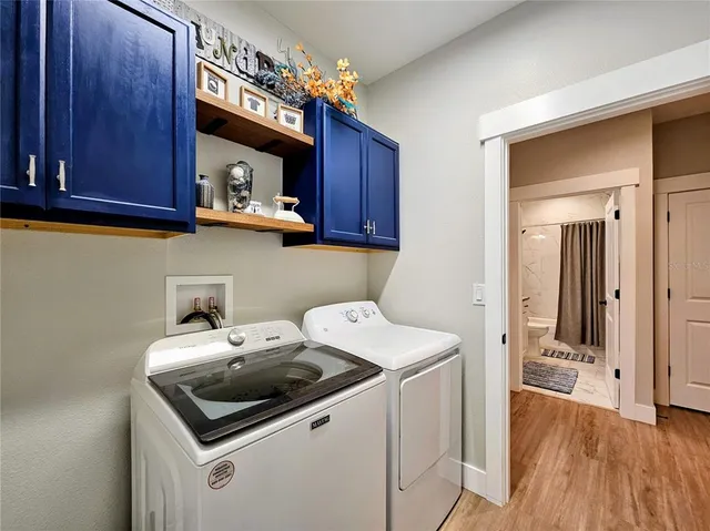 a utility room with dryer washer and a view of kitchen