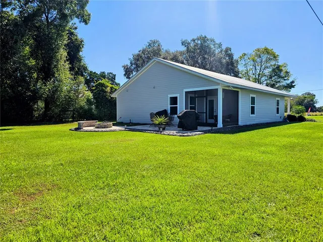 a view of a house with a yard and sitting area