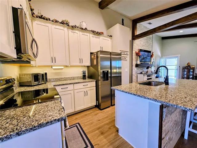 a kitchen with stainless steel appliances granite countertop a sink stove and refrigerator