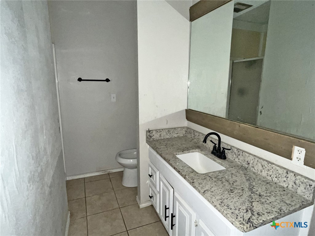 104 East Elms Road Killeen, TX 76542 - Photo 17 of 24 a bathroom with a granite countertop sink and a toilet