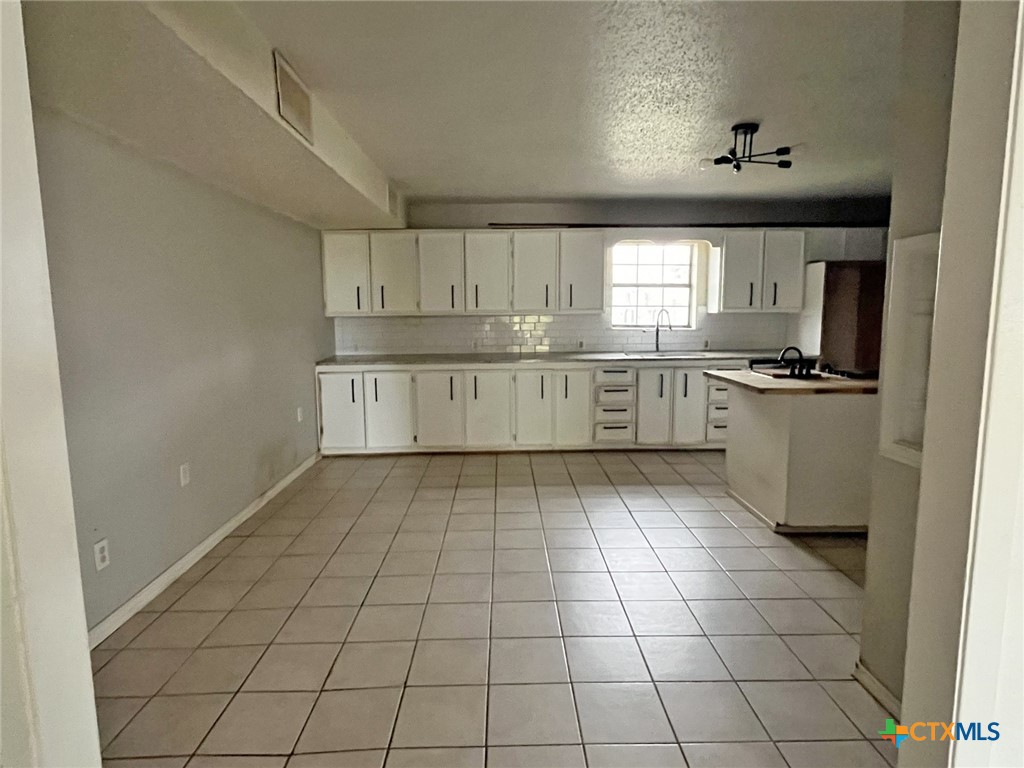 104 East Elms Road Killeen, TX 76542 - Photo 4 of 24 a kitchen with a stove a sink and cabinets