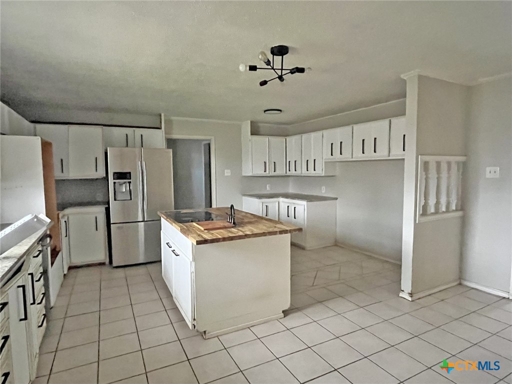 104 East Elms Road Killeen, TX 76542 - Photo 6 of 24 a kitchen with granite countertop a refrigerator and a stove top oven