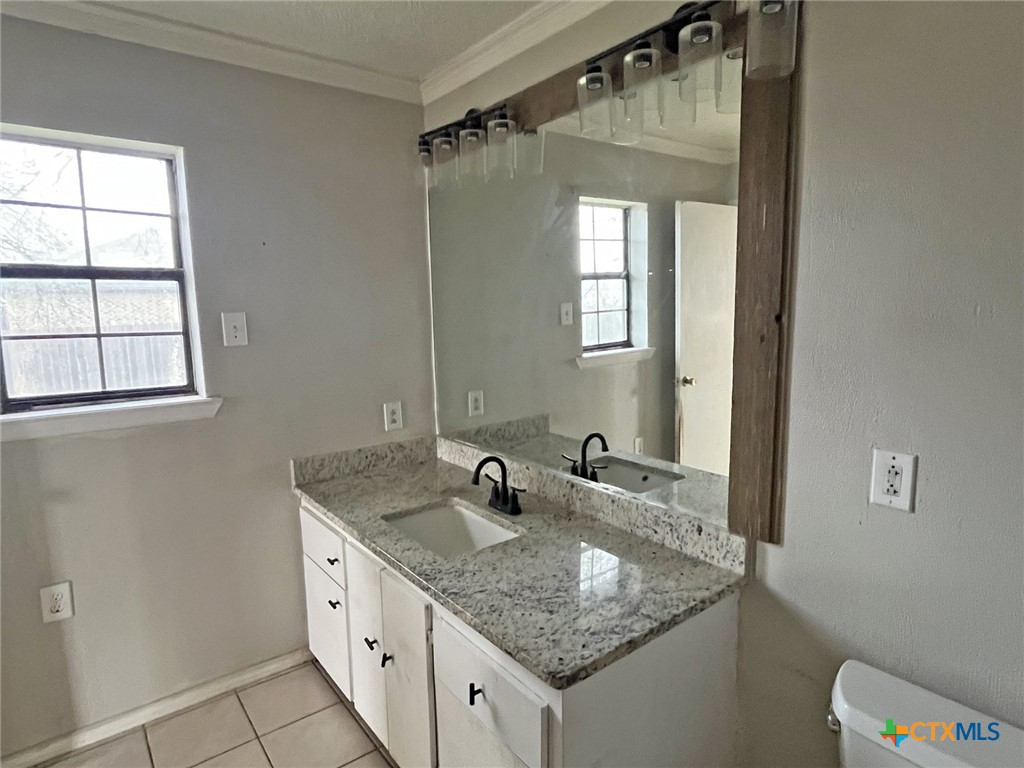 104 East Elms Road Killeen, TX 76542 - Photo 9 of 24 a bathroom with a granite countertop sink and a mirror