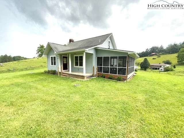 a view of a house with a big yard and large trees