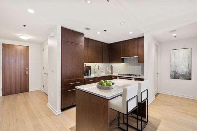 a kitchen with kitchen island a stove a table and chairs in it