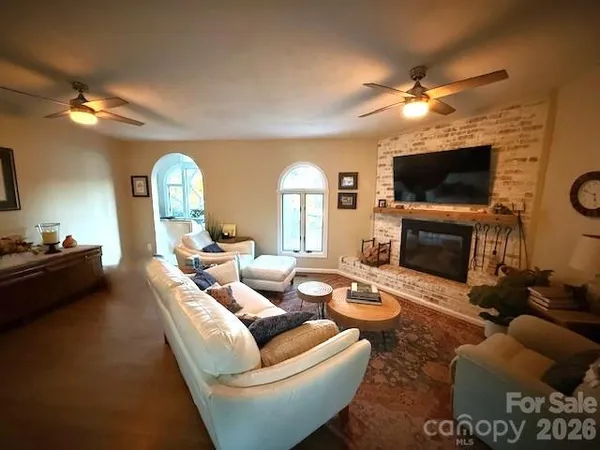 a living room with furniture a fireplace and a flat screen tv