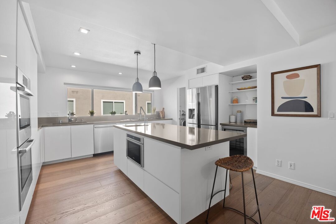 13065 Mindanao Way, Unit 3 Marina del Rey, CA 90292 - Photo 8 of 25 a large kitchen with stainless steel appliances kitchen island a large counter top and a view of living room